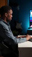 Vertical Young programmer engineer writing binary code data on terminal window, doing freelance work at home setup. Software developer working on troubleshooting with programming language. Camera B. video