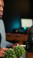Vertical Black guy editor working with dual monitors for creative content, editing footage and does color grading for the media creation. Male professional works in post production. Camera A. video