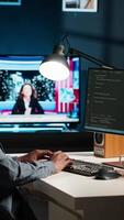 Vertical African american expert at desk using pc for programming and data analysis. Young networking expert working from his home setup, manages information technology and data center. Camera B. video