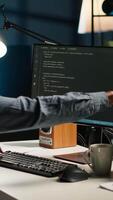 Vertical African american male programmer working on cloud computing with an algorithm, writing code for optimization on terminal window. IT specialist inserts html code, server security. Camera B. video