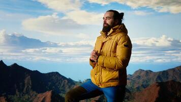 Traveler stands alone in the high altitude wilderness admiring the breathtaking scenery, enjoying fresh air and stunning mountain top landscape. Peaceful atmosphere inspire mindfulness. Camera B. video