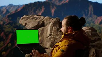 Trekker takes in the panoramic landscape next to isolated mockup screen, where the peaceful mountain scenery and open sky symbolize adventure and perseverance. Wanderlust. Camera B. video