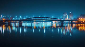 A night view of a bridge illuminated by city lights reflecting on the water. photo