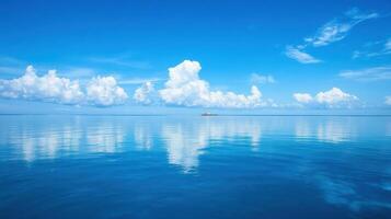 A serene seascape featuring calm waters and fluffy clouds reflecting in the ocean photo