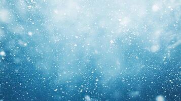 A serene winter scene with snowflakes gently falling against a blue background photo