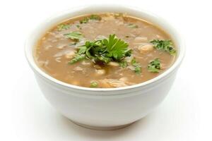 A bowl of savory soup garnished with fresh herbs photo