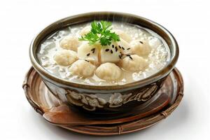 A bowl of soup with dumplings and tofu, garnished with cilantro and sesame seeds photo