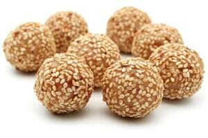 A cluster of sesame-coated sweet treats arranged on a white background photo