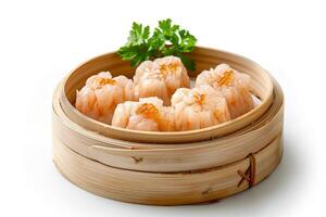 A bamboo steamer containing shrimp dumplings garnished with herbs photo