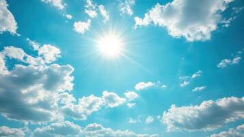 A bright sun shining in a clear blue sky with fluffy clouds photo