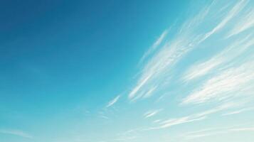 A clear blue sky with soft, wispy clouds, conveying tranquility and openness. photo