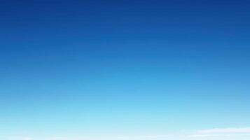 A clear blue sky with subtle gradient and wispy clouds near the horizon photo