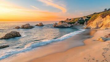 A serene beach at sunset with gentle waves and rocky formations along the shore photo
