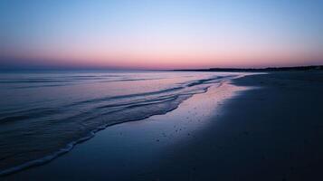 A serene beach scene at dusk with gentle waves and a colorful sky photo