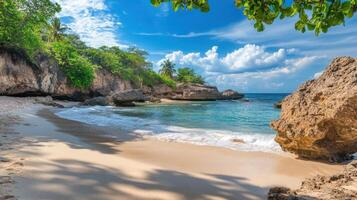 A serene beach scene with clear water, gentle waves, and lush greenery under a blue sky photo