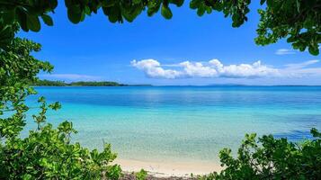 A serene beach view featuring clear turquoise waters and a bright blue sky photo