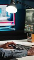 vertical africano americano camarógrafo trabajos en edición película imágenes a hogar, haciendo Lanza libre contrato para enviar producción escenas editor de corrección blanco equilibrar y color calificación, ordenador personal software. cámara b. video