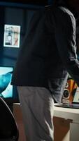 Vertical Remote worker organizing project data reviewing his handwritten notes, browsing web for research. Self employed black person managing his freelance job and daily schedule at home. Camera A. video