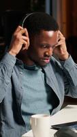 Vertical African American guy waving at a call connection with workmates, working remotely from his apartment and participating in executive meetings. Virtual communication. Camera B. video
