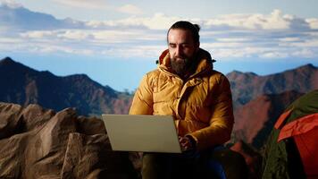 Hiker with a technology obsession and strong signal working in nature, climbing the top of the mountain and connecting to work platform. Workaholic person enjoying internet everywhere. Camera B. video