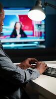 Vertical African american man working on PC to write code and programming in artificial intelligence and deep learning. Male IT engineer using pc to ensure cyber security, neural network. Camera B. video
