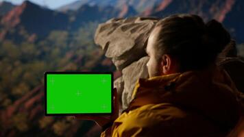 Happy adventurer standing at the rocky top next to copy space display, feeling the power of accomplishment. Examines the mountain range, peaceful sky and vast wilderness. Camera B. video