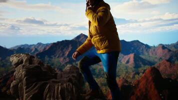 Trekker enjoys the high altitude landscape and making a phone call, panoramic mountain views and crisp air provide the perfect scene for relaxation. Using strong signal on his smartphone. Camera A. video