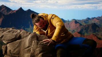 Determined climber standing at the summit enjoys peaceful moment of success. Vast sky, mountain range and fresh air highlighting the essence of freedom, wellness and exploration. Camera B. video