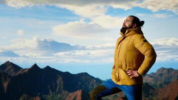 Hiker pauses to admire the panoramic mountain scenery on the hill top, endless sky and rugged peaks creating a breathtaking backdrop for mental clarity. Adventure seeker. Camera B. video