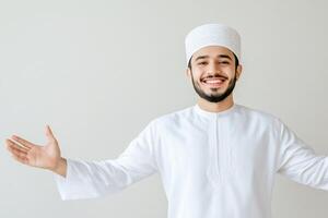 Smiling Muslim man in traditional white thobe with open arms. photo
