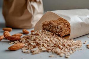 Oatmeal granola bar spilling from paper packet photo