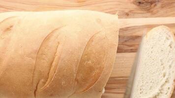 A loaf of bread being sliced into even pieces, revealing its soft, airy texture. video