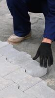 Worker installing paving stones with mallet and level tool video
