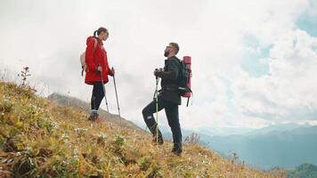 Tourists couple man and woman hikers having rest stop hiking in mountains. video