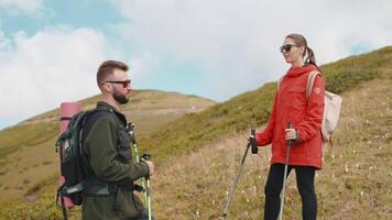 travel in mountain in summer vacation, portrait of two tourists with sticks for nordic walk on slope video