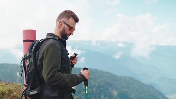 confident backpacker walking on mountain slope, using sticks for nordic walk, ecotourism in highland video