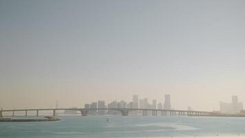 Seascape with modern bridge and cityscape on background in fog, bright light. video