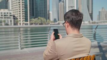 man with smartphone in city center, businessman checking email and messages in working chat video