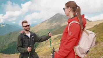 Couple of young hikers smiling talking resting from trekking on mountain slope. video
