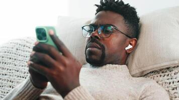 Man listens music in phone rest at home. video