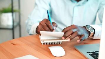 Man write notes in notepad in workplace. video