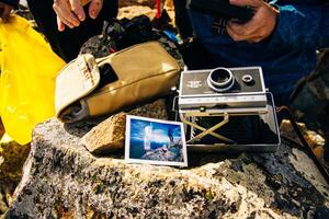 old Polaroid camera and a photograph taken on a mountain trip. nepal - september 12th 2023 photo