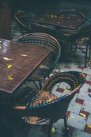 wooden table with wicker chairs in a summer cafe in autumn photo