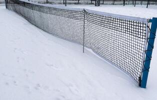 Snow covered tennis court nets in a weather delay concept, with space for text on the top and bottom photo