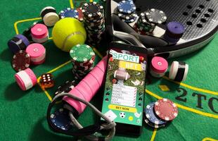 Conceptual background of online sports betting with objects representing different sports, money and chips to bet. Front view. photo