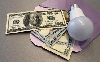 Energy saving light bulbs with american currency , dollars on a background. Payment for electricity, financial condition of the energy market, increase in energy prices. photo
