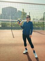 Female player learning fundamental skills in volleyball. Girl practicing digging to receive and save the ball from hard-given attack of the opponents photo