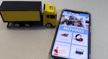 Smartphone and toy truck on a light background. Delivery concept, online ordering, phone application, moving. Delivery by car to anywhere photo
