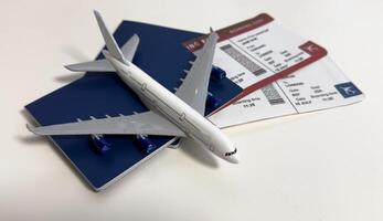 Toy airplane and passport with tickets on gray background, top view photo