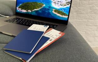 travel and vacation concept. top view of airplane, plane, laptop, passport and tickets on the table photo